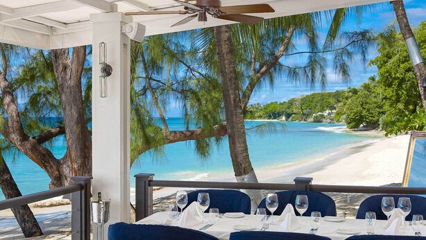 A dining area with a view of a beach and palm trees. - Beachcombers villa, Porters Court, Fairmont beach passes, few meters to Lonestar (Porters)