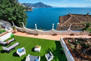 A coastal villa with a terrace, outdoor seating, and a view of the sea. - Turo's Eden ( Brand New Loft)Exclusive Loft in Conca dei Marini (Conca dei Marini)
