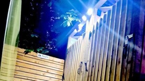 A wooden deck with a sauna area, including a bench and a door labeled "TOILETS". - Bell Tent Village (Nottingham)