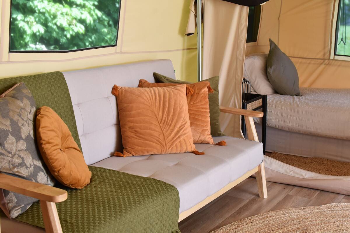 Ein gemütliches Interieur mit einer Couch und einem Bett, jeweils mit Kissen.