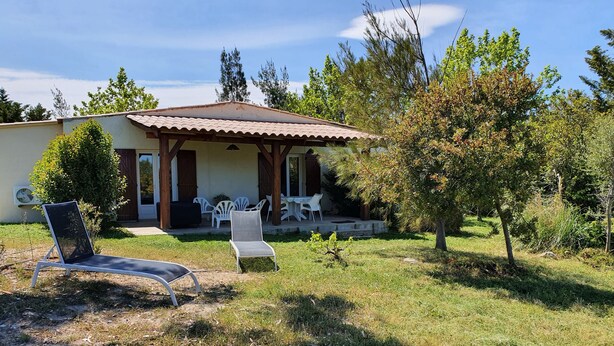 Une maison dotée d’un patio couvert, d’un espace salon extérieur et d’une pelouse.