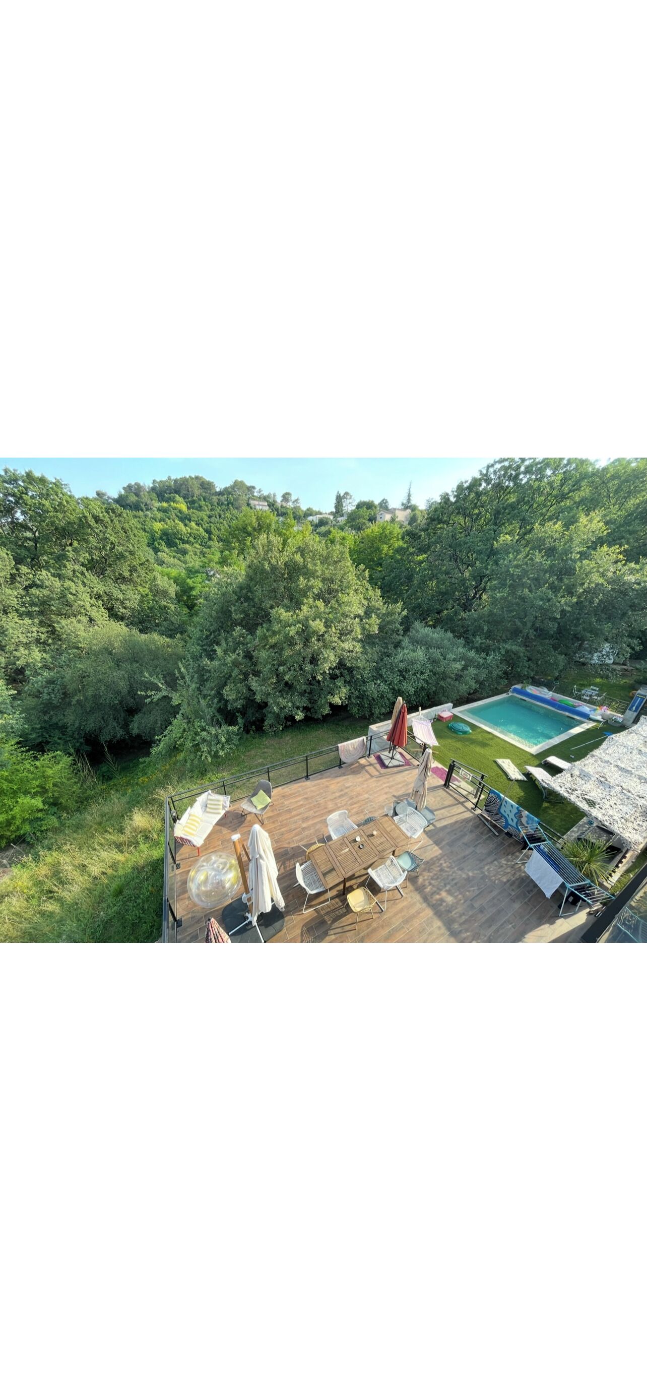 Eine Dachterrasse mit Pool, umgeben von üppiger Vegetation.