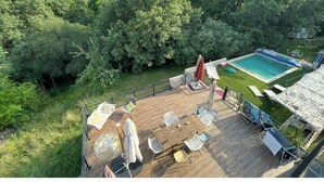 Terraza en la azotea con piscina, rodeada de exuberante vegetación.
