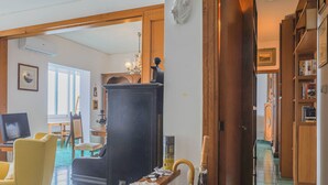 A living room with a television, yellow armchair, and a large cabinet. - Apartament in Amalfi ID 4178 (Amalfi)