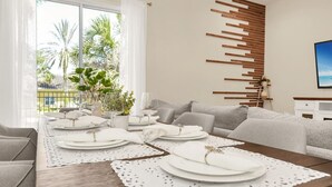 Uma área de jantar moderna com uma mesa de madeira posta para quatro pessoas, pratos brancos e vista para palmeiras através de grandes janelas.