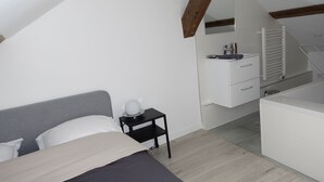 A bedroom with a bed, a nightstand, a dresser, and a bathroom with a sink and mirror. - Dijon : Superbe Appartement Hyper Centre en Duplex (Dijon)