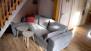 A living room with a grey sofa, two small tables, and a staircase. - Chalet, 350m from ski slopes, parking, tv, 104m², Les Gets (Les Gets)