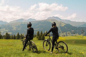 Two cyclists on a grassy field with a mountainous backdrop. - 1st floor, parking, ski locker, 94m², Les Gets (Les Gets)