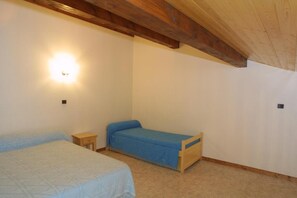 A bedroom with two beds, a nightstand, and a wall-mounted light. - 1st floor, parking, ski locker, 94m², Les Gets (Les Gets)