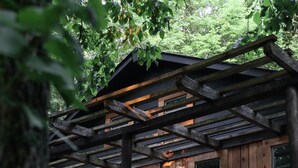 Une cabane en bois dotée d’une terrasse en bois et de nombreuses fenêtres.