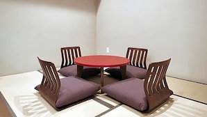 A room with a round table and four chairs with cushions. - Y S Inn Naha Oroku Ekimae (Naha)
