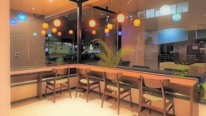 A modern bar area with wooden chairs and a glass partition. - Y S Inn Naha Oroku Ekimae (Naha)
