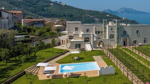 A modern villa with a swimming pool, surrounded by lush greenery and overlooking a coastal landscape. - Tenuta Sirignano Villa Nord e Sud (Massa Lubrense)