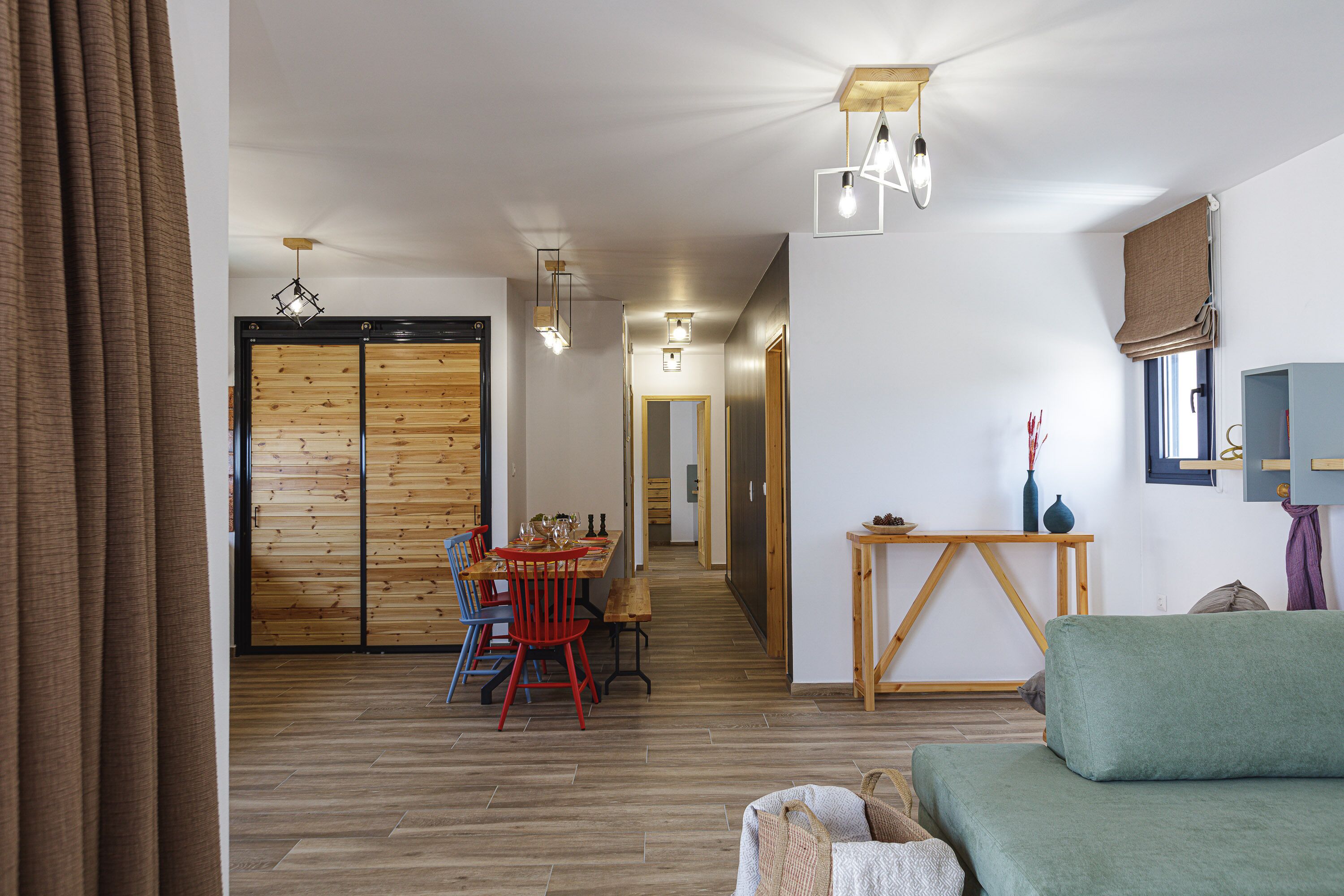 Een modern interieur met een eethoek, een bank en een houten vloer.