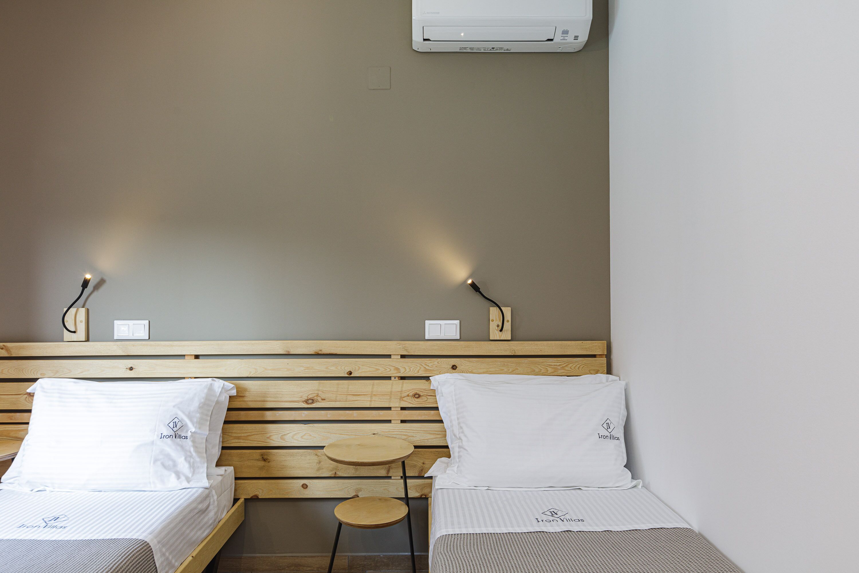 Een slaapkamer met twee bedden, elk voorzien van een kussen en een klein rond tafeltje.