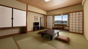 A traditional Japanese room with tatami flooring, a low table, sliding doors, a television, and a view of the outdoors. - Mercure Saga Karatsu Resort (Karatsu)