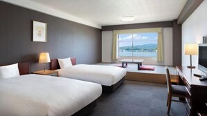A hotel room with two beds, a desk, a chair, a TV, and a window with a view. - Mercure Saga Karatsu Resort (Karatsu)