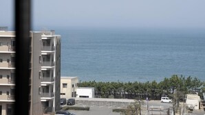 A view of a coastal area with a building, a parking lot, and the sea. - Mercure Saga Karatsu Resort (Karatsu)