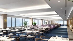 A spacious restaurant with high ceilings and large windows, offering a view of the outdoors. Tables are neatly arranged with chairs, and there are potted plants adding greenery. - Mercure Saga Karatsu Resort (Karatsu)