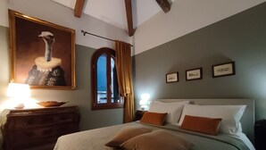 Un dormitorio con cama, cómoda, un cuadro de avestruz y una ventana con cortinas.