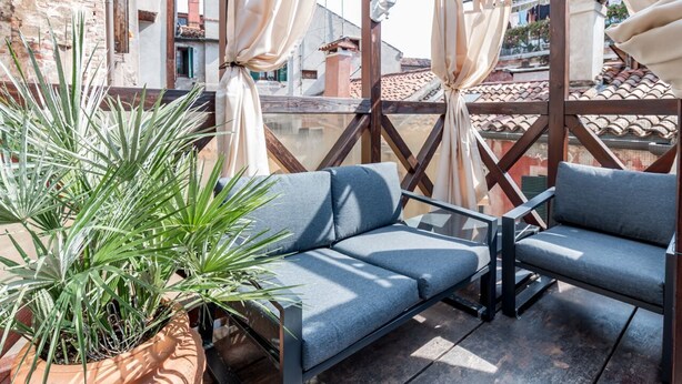 Un espacio al aire libre con sofás y una planta en maceta.