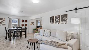 Un salon comprenant un canapé, une table basse et un coin repas avec des chaises et une table.