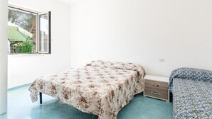 Una camera da letto con un letto, un comodino e una finestra.