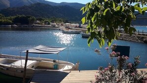 Una barca ormeggiata in un lago tranquillo con montagne sullo sfondo.