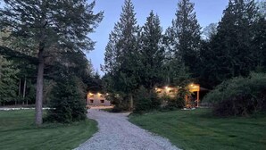 A gravel path leading to a building surrounded by trees.