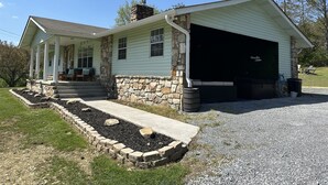 Une maison à deux étages avec une façade en pierre, un porche abrité et un garage.