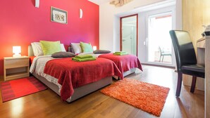 Un dormitorio con dos camas, un escritorio y una silla.