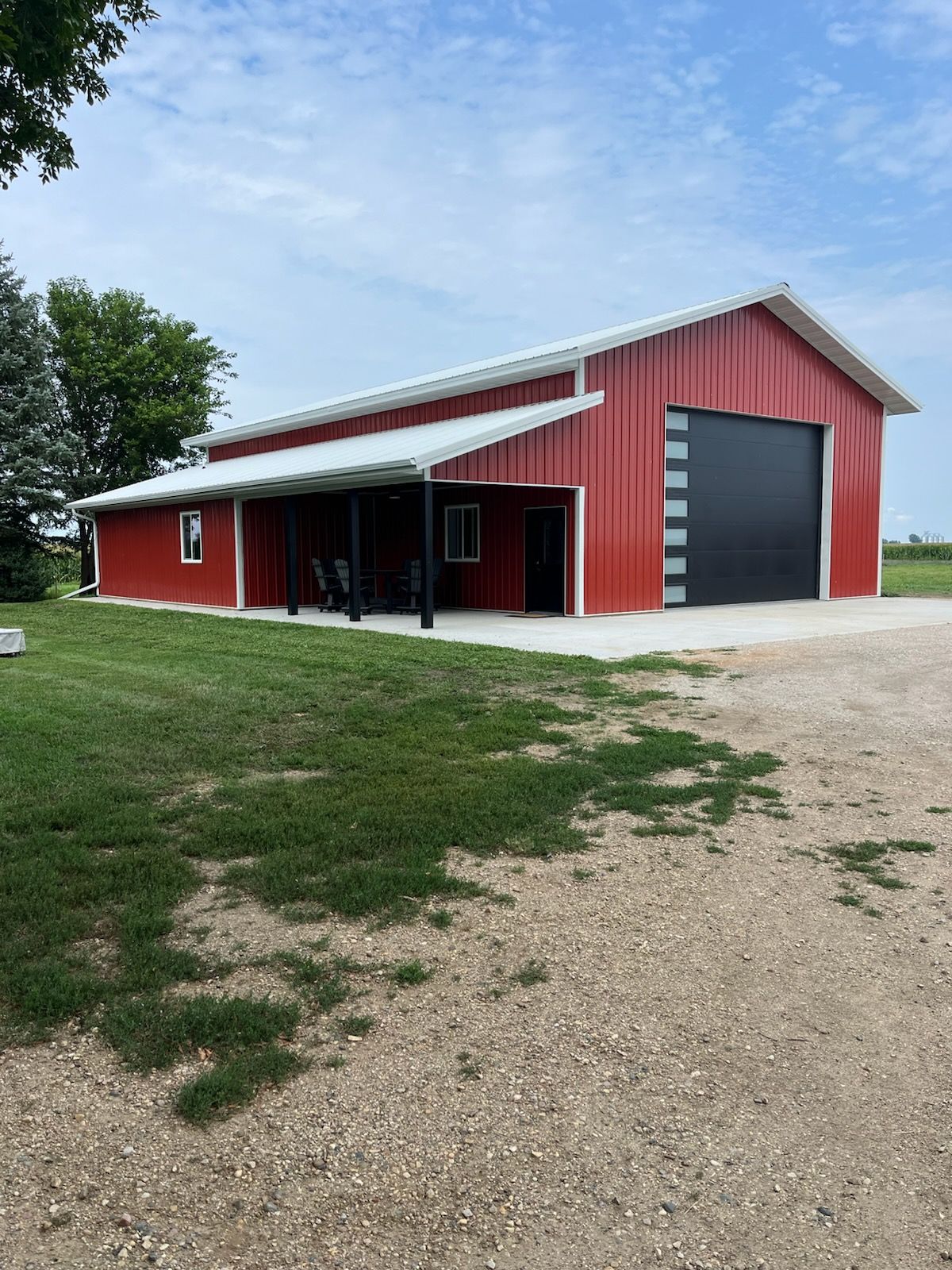 A red building with a covered porch and a large garage door.