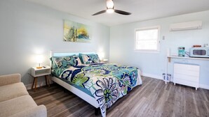 A bedroom with a bed, bedside table, lamp, and a ceiling fan. - Hugo - Offshore Beach Club (Buxton)