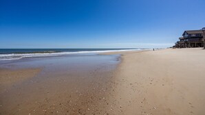 A beach with a wooden pier extending into the ocean, a clear sky, and a sandy shore. - Hugo - Offshore Beach Club (Buxton)