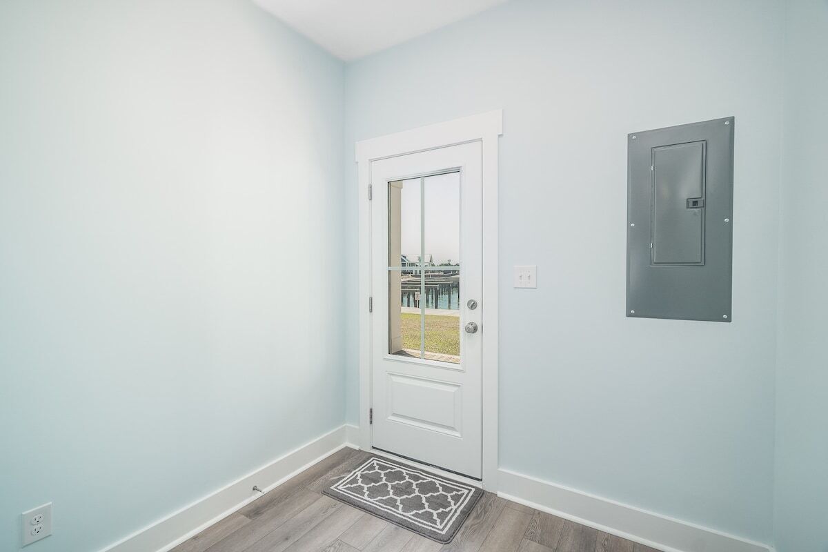 Une pièce avec une porte blanche, une petite fenêtre et un mur bleu clair.