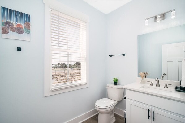 Un baño moderno con inodoro, lavamanos y ventana.
