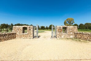 Enter a serene property through this rustic stone gate, flanked by stone walls with small windows.