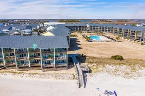 A resort with multiple buildings, a pool, and a beach area.