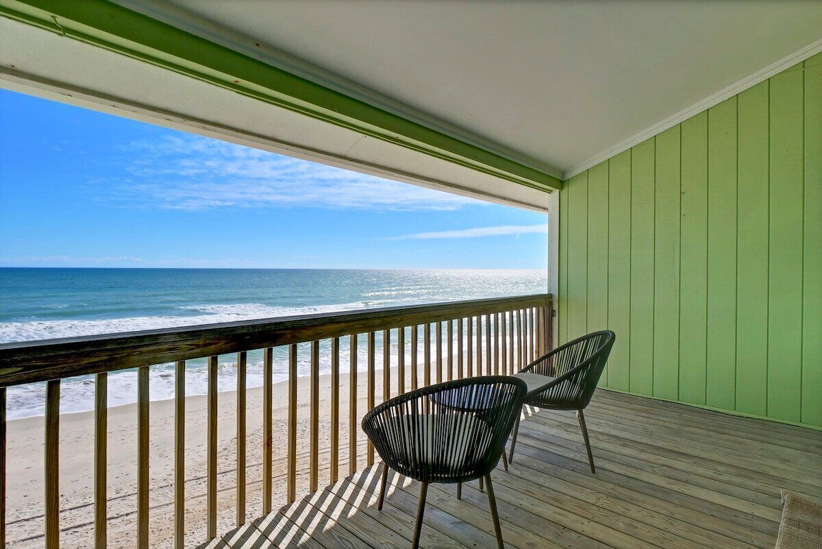 Un balcón con vista a la playa y al océano.