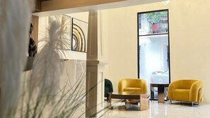A lobby with a wooden ceiling, a large window, and two yellow armchairs. - RIG Colonial Experience (Santo Domingo)