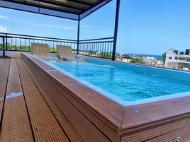 Una piscina al aire libre, sillones reclinables de piscina
