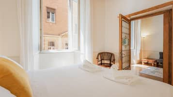 Una camera d'albergo con un letto, una sedia, un armadio in legno e uno specchio grande.