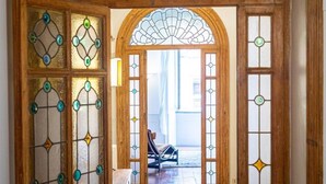 A wooden door with stained glass panels and a fan-shaped window above. - Frattina Atmosphere apartment (Rome)
