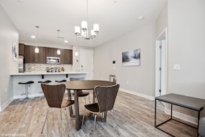 A modern kitchen with dark wood cabinets, a stainless steel refrigerator, and a built-in microwave.