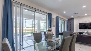 A modern dining area with a glass table, chairs, and a decorative vase. - Beautiful and Cozy Home at Sonoma Resort (Kissimmee)