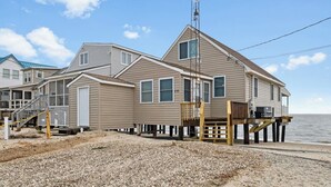Une maison située en bord de mer, dotée d’un quai, de plusieurs terrasses et offrant une vue dégagée sur l’océan.