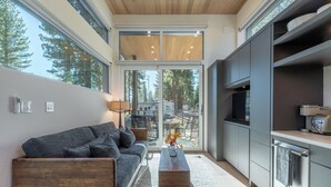A modern kitchen with a grey countertop, wooden cabinets, and a built-in oven. - Village Camp Truckee (Truckee)