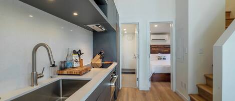 A modern kitchen with a large island, stainless steel appliances, and a wooden countertop.