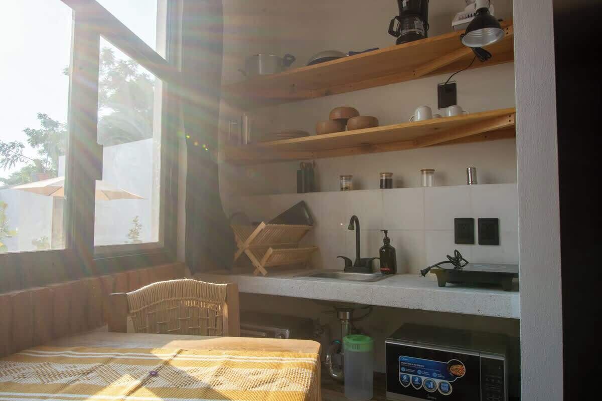 Eine kleine Küche mit Holzböden, einer Spüle und einer Kaffeemaschine.