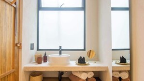 A bathroom with a large window, a sink, and towels.